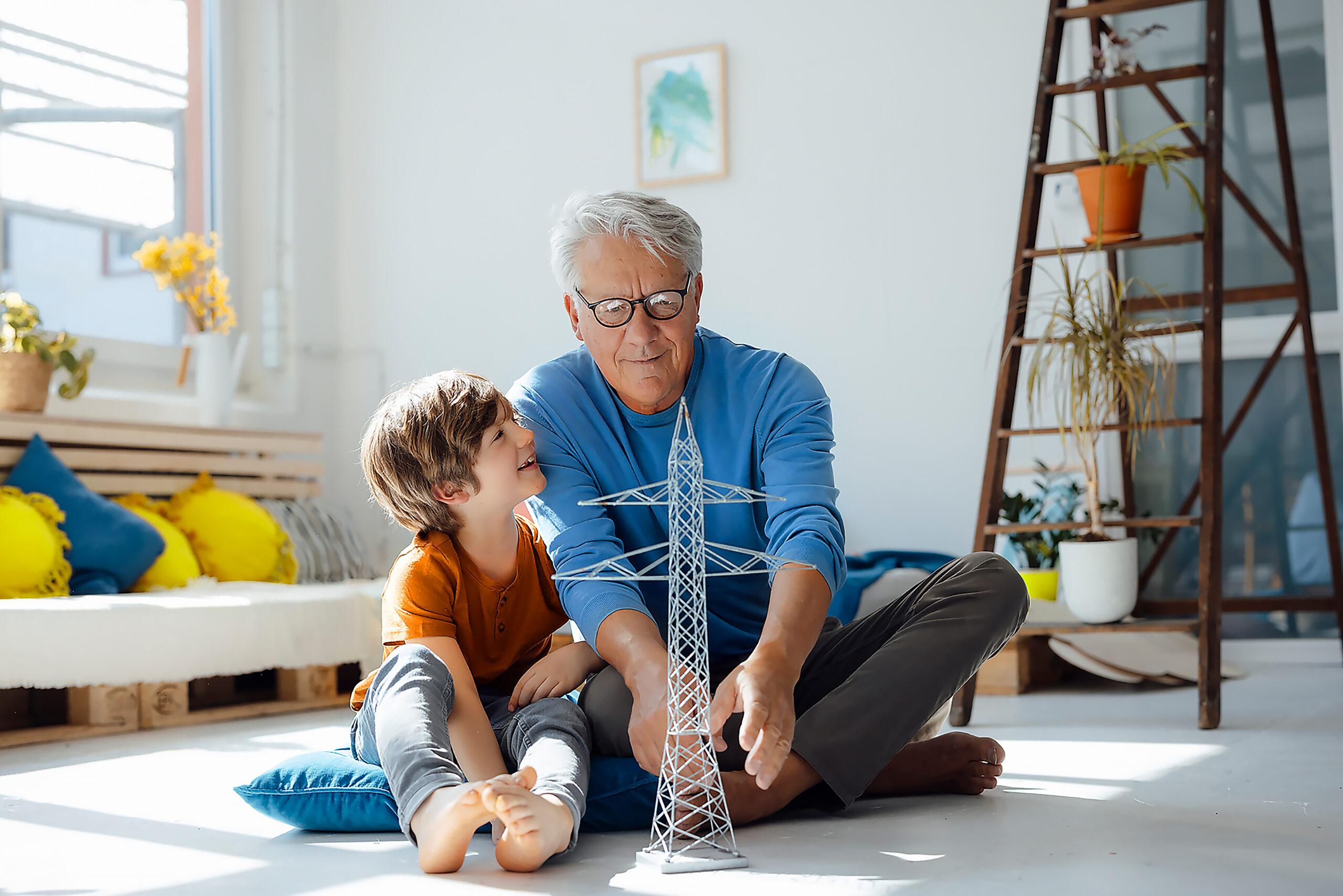 TWS Naturstrom – Opa spielt mit Enkel im Wohnzimmer mit